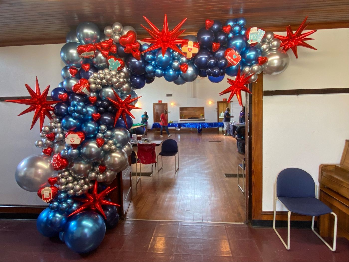 Navy, silver and red balloon arch framing a hall entrance