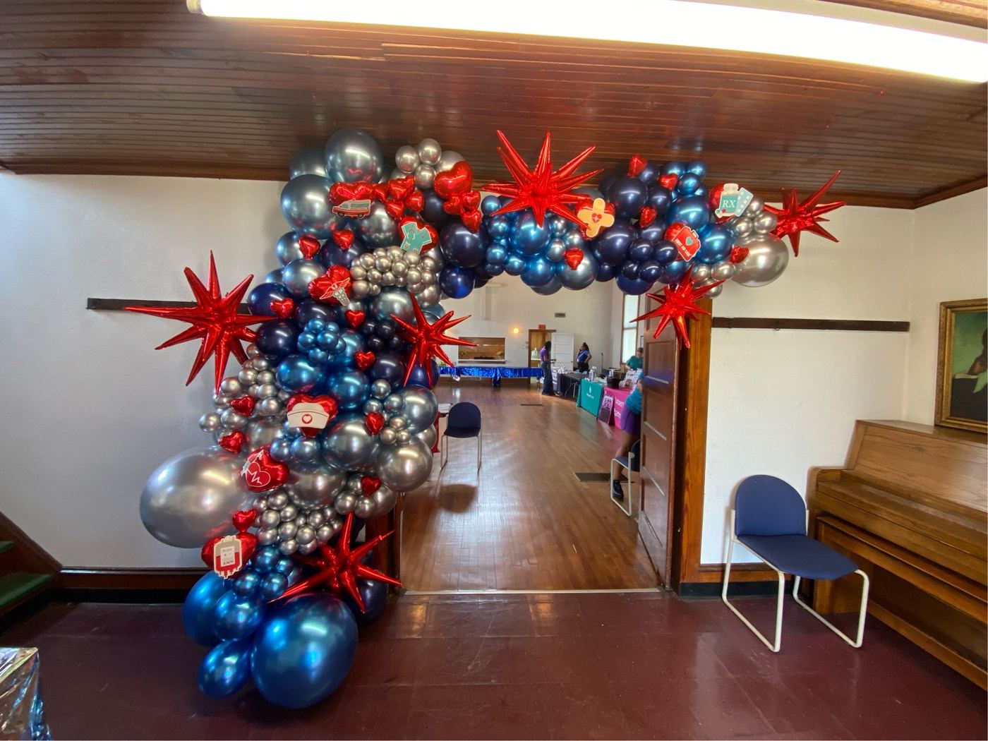 Navy and red balloon arch in a reception hall