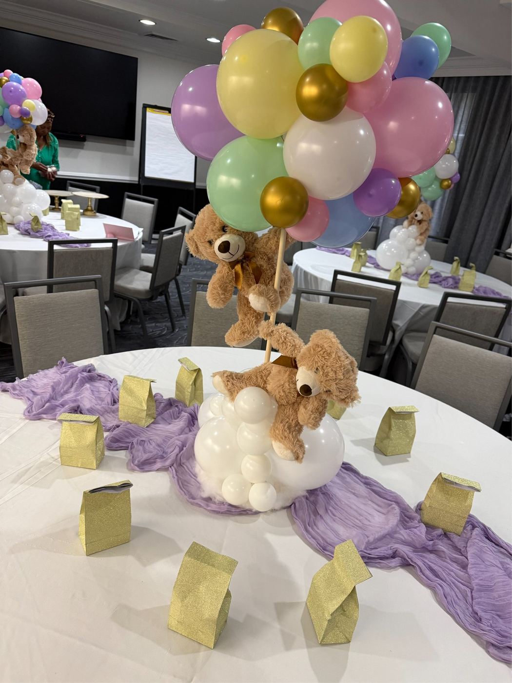 Baby shower table with teddy bears and pastel balloon garland