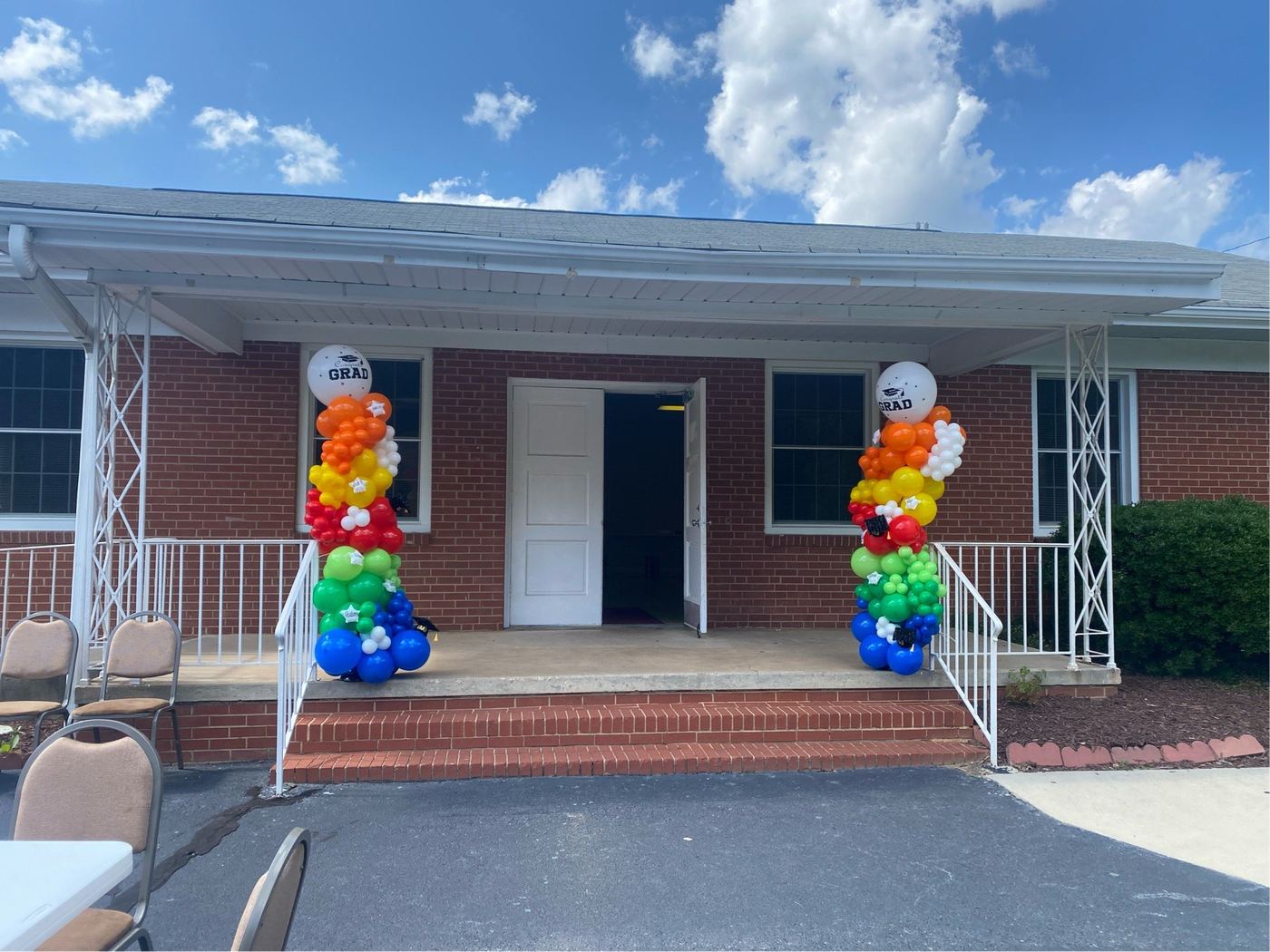 Graduation balloon columns framing a front entrance outdoors