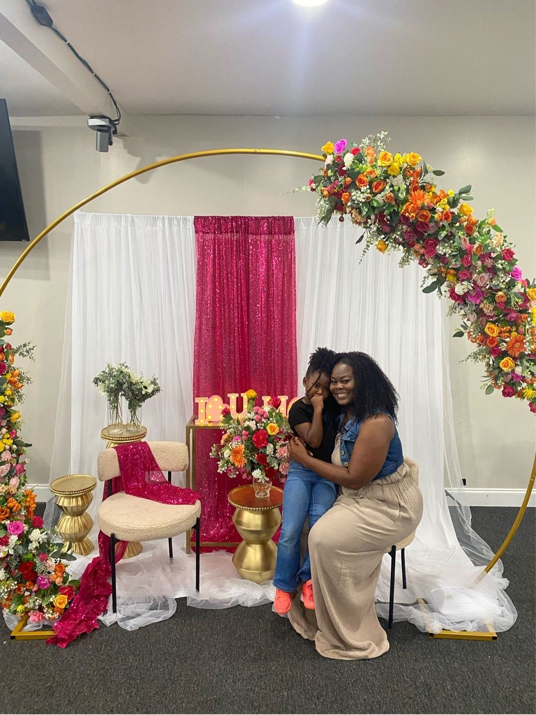 Floral hoop arch with sequin backdrop styled for a celebration