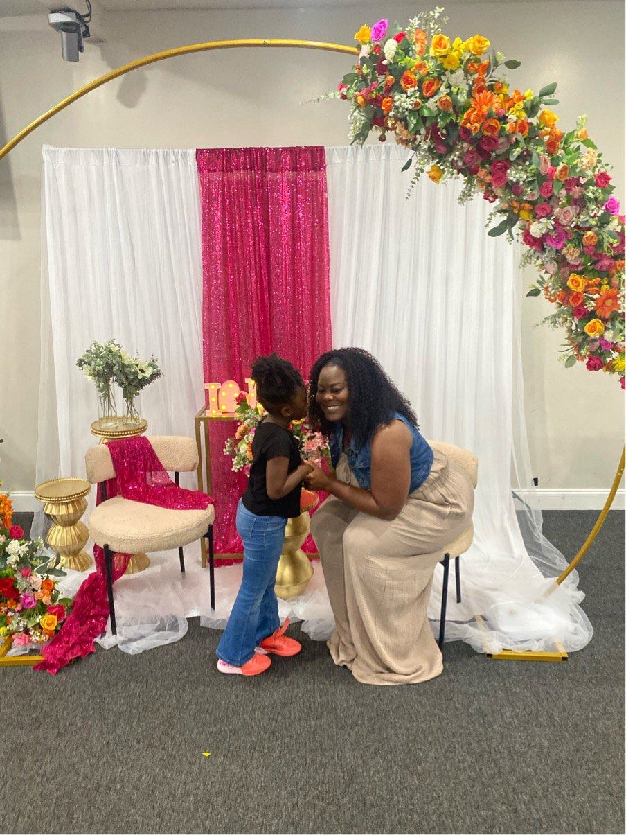 Mother and child in front of a floral hoop arch